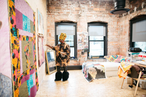 A studio at The Union for Contemporary Art, featuring an artist painting canvases.
